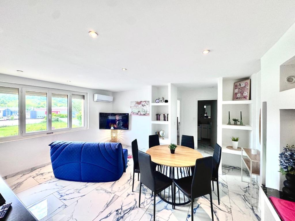 a living room with a table and a blue couch at T3 moderne - Clim - Parking privé 4 couchages in Decazeville