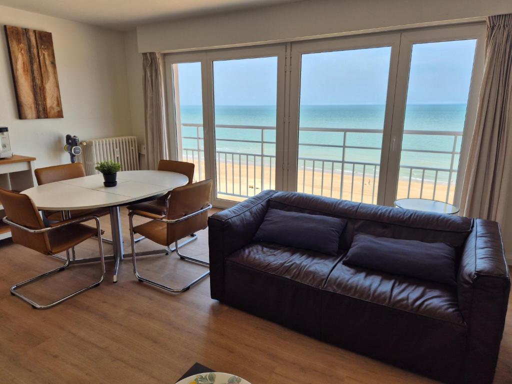 a living room with a couch and a table at Sealview Nevada in Koksijde
