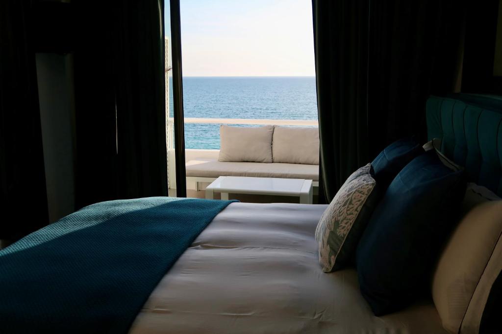 a bedroom with a bed and a view of the ocean at Bela Vista Suites in Carvoeiro