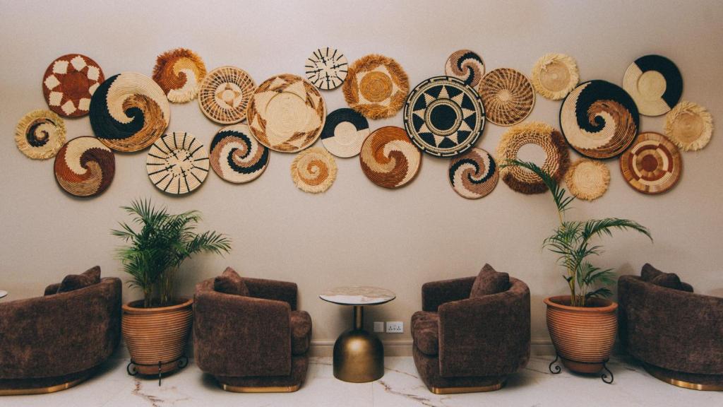 a wall with a bunch of plates on the wall at Hemingway's Hotel in Entebbe