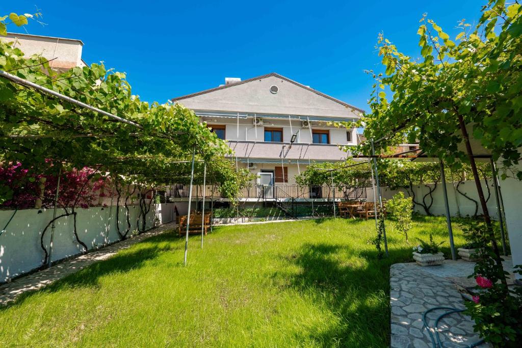 a yard of a house with trees and a fence at Kalpazo Rental Kaya Stays in Golem
