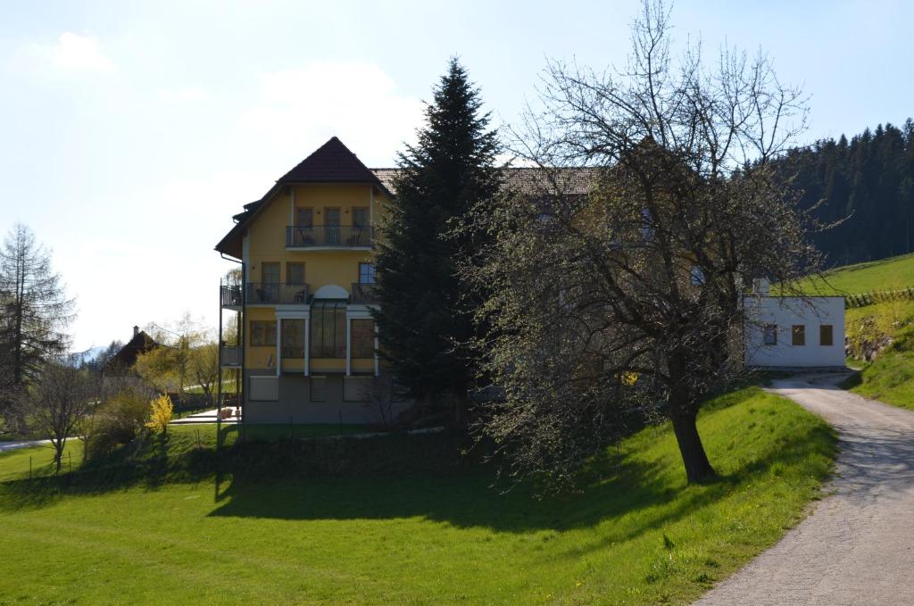 a house on a hill with a tree in front of it at Wildwiesenhof in Miesenbach