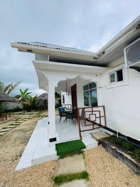 a small white house with a patio at Malaika white house in Kiwengwa