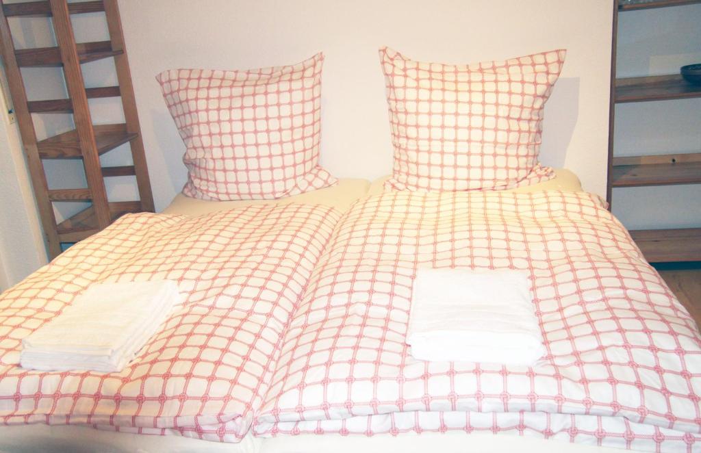 Bett mit rosa und weiß karierter Bettwäsche und Kissen in der Unterkunft Holiday Apartment Zwinger in Dresden