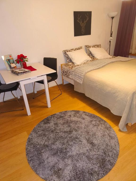 a bedroom with two beds and a desk and a table at Jaakonkatu City Apartment in Rovaniemi