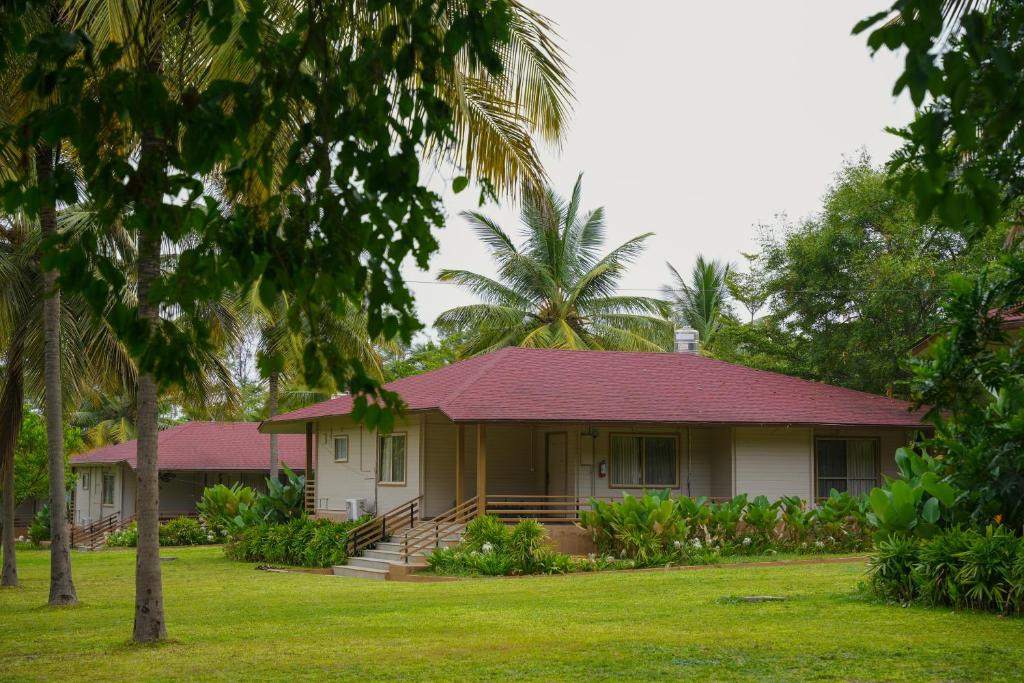 a house with a pink roof and palm trees at White Petals Resort in Bangalore