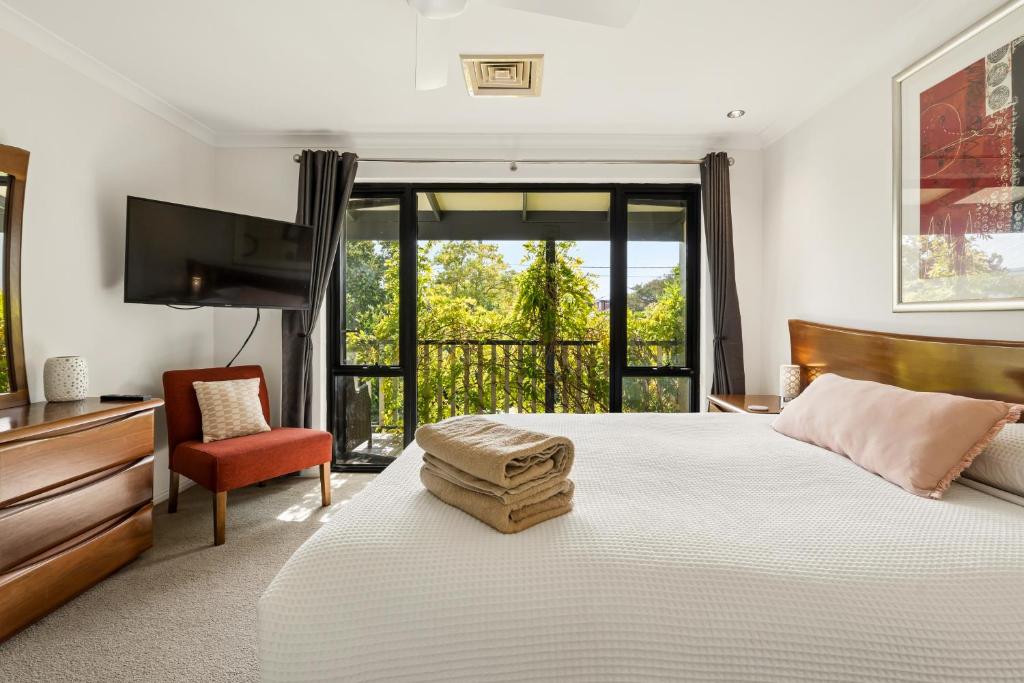a bedroom with a bed and a television and a chair at Group stays for Friends Families Weddings and Events Walkable to Fremantle and attractions Super Spacious with garden and courtyard and balcony and parking for 2 cars Sleeps 6 3BD 3BR in Fremantle