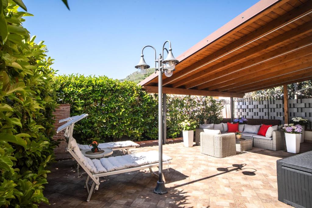 a patio with a bench and a light pole at Brisa Home Beach in Mazzeo