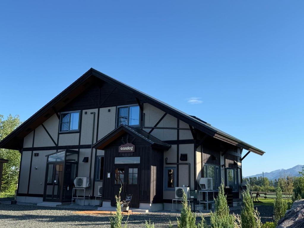 a black and white building with chairs in front of it at Furano Cozy Whole House for 6 - Near lavender farm and Ski Resort - free parking in Nakafurano