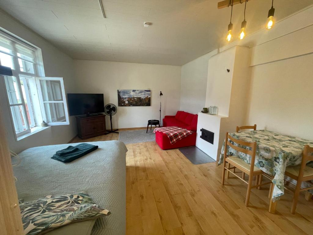 a living room with a table and a red couch at Kantreküla Apartment - lemmikloomasõbralik ja kodune in Viljandi