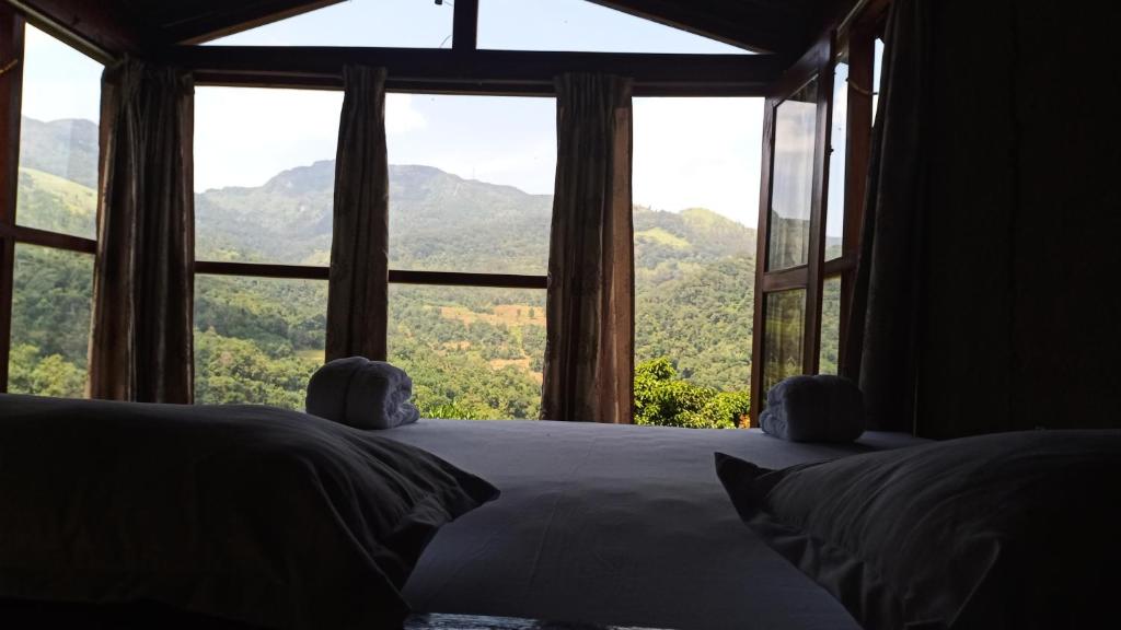 a bedroom with a bed and a large window at Trekker's Lodge in Matale