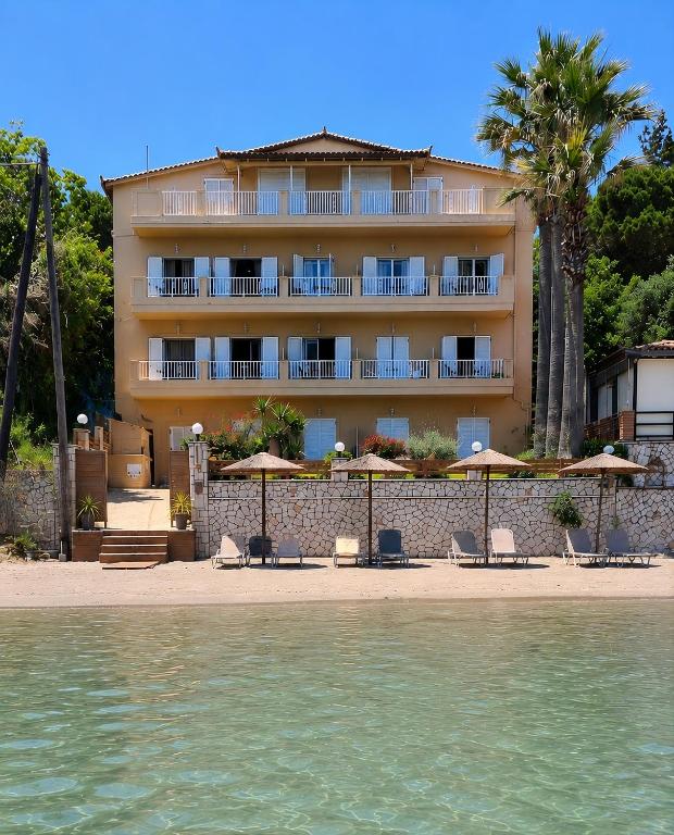 a hotel on the beach with chairs and umbrellas at Nel Mare Studios in Laganas