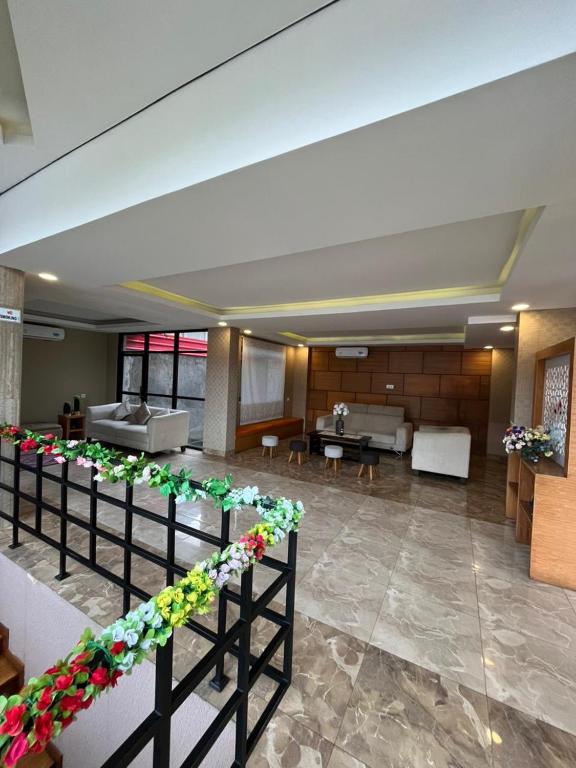 a lobby with a waiting area with flowers on a fence at Benhas Hotel Bukittinggi in Bukittinggi