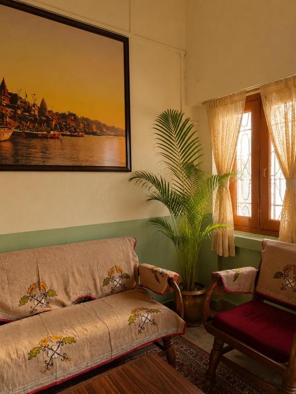 a living room with a couch and a plant at Shristays in Varanasi