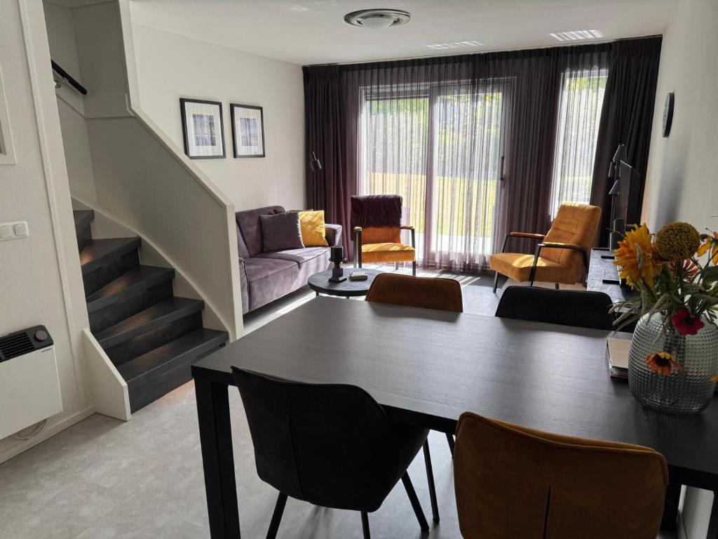 a living room with a table and chairs and a couch at Prins Heerlijk Amelander Kaap 81 in Hollum