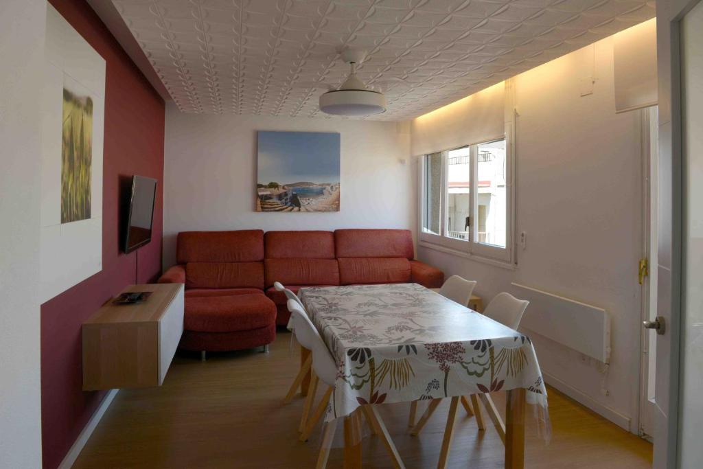 a living room with a red couch and a table at Pedro in Roses