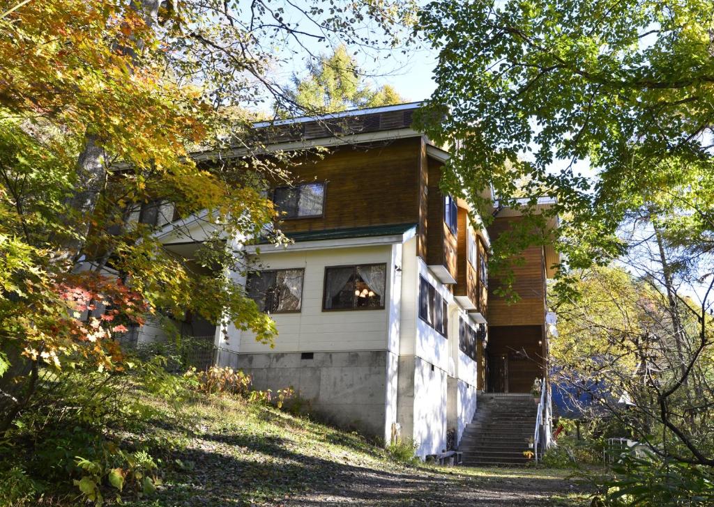a house with a dog sticking its head out the window at Wolke Lodge in Shinano