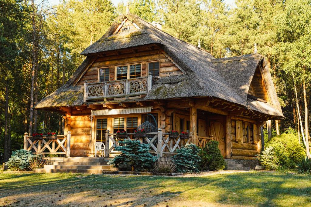 a log cabin with a thatched roof at Leśna Oaza in Sierpc
