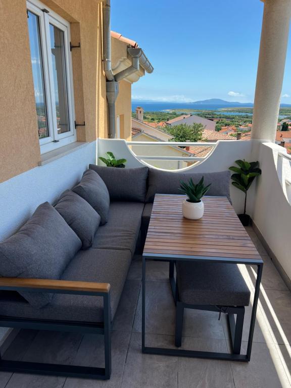 a couch and a table on a balcony at Apartman Ariana in Ližnjan