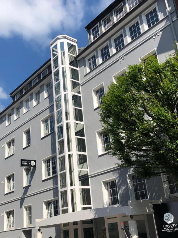 a tall white building with a tall tower at Arthotel ANA Liberty, Trademark Collection by Wyndham in Bremen