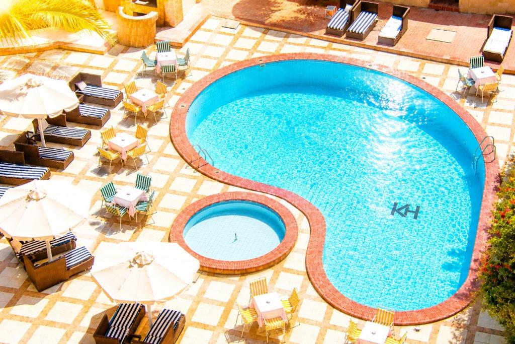 an overhead view of a swimming pool with chairs and umbrellas at Karnak Hotel Luxor in Luxor