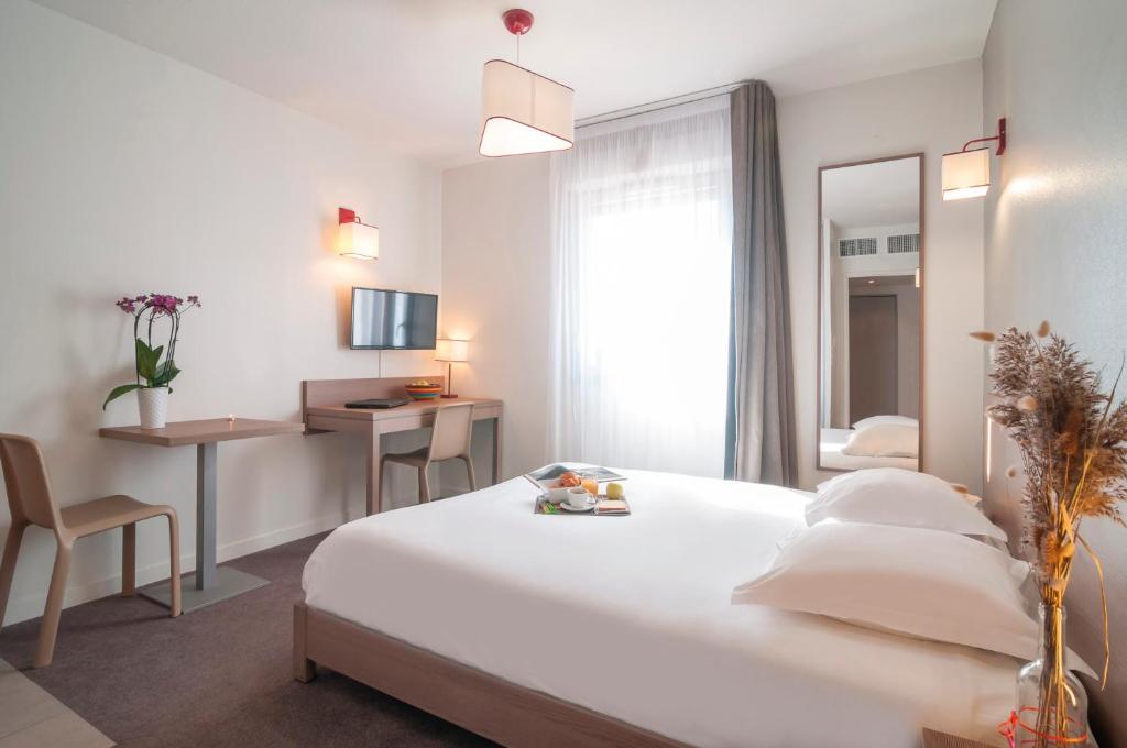 a hotel room with a large bed and a large window at Appart'City Perpignan Centre Gare in Perpignan