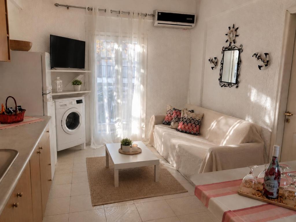 a white living room with a couch and a table at NiRa house in Pefkochori
