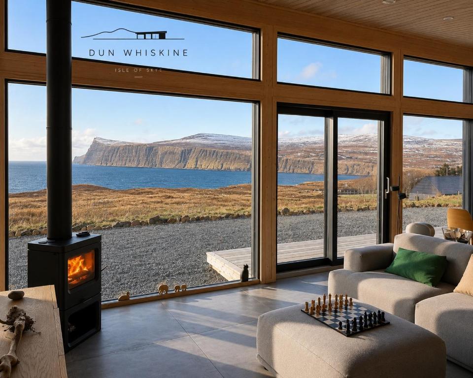 a living room with a fireplace and a view of the water at Luxury Nordic Lodge with private Sauna in Glendale