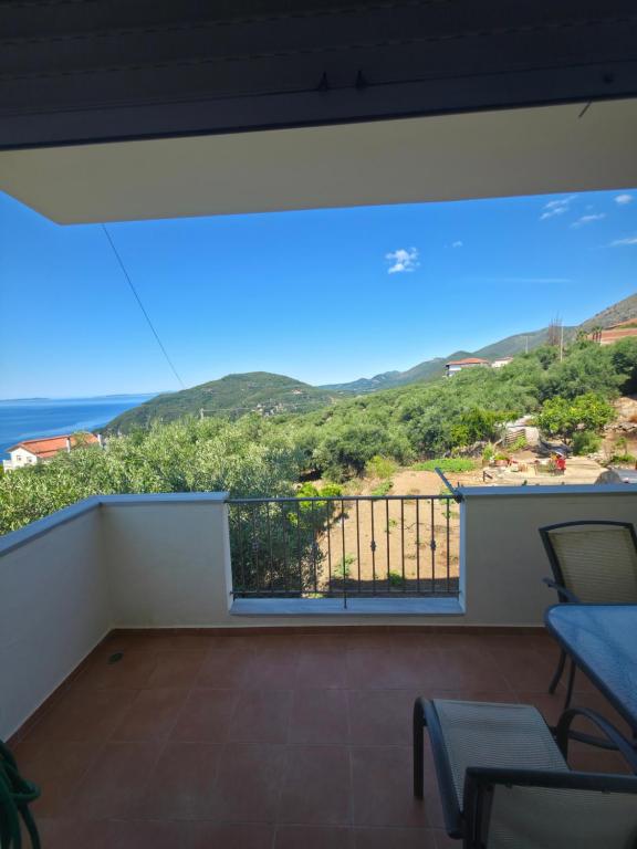 a room with a balcony with a view of the ocean at Olive Tree Apartments in Parga