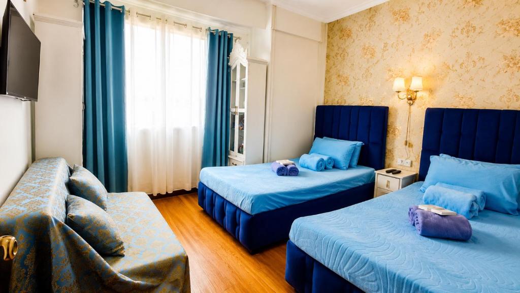 a hotel room with two beds and a couch at Condotels at Albergo Hotel Baguio in Baguio