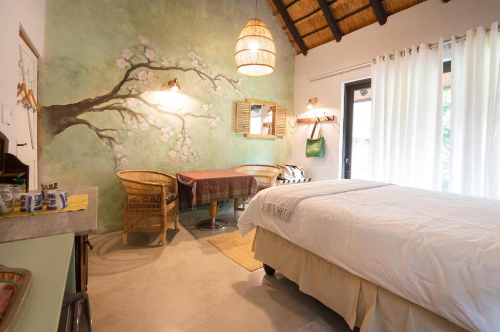 a bedroom with a bed and a desk and a table at The Olive Room in Kampersrus AH