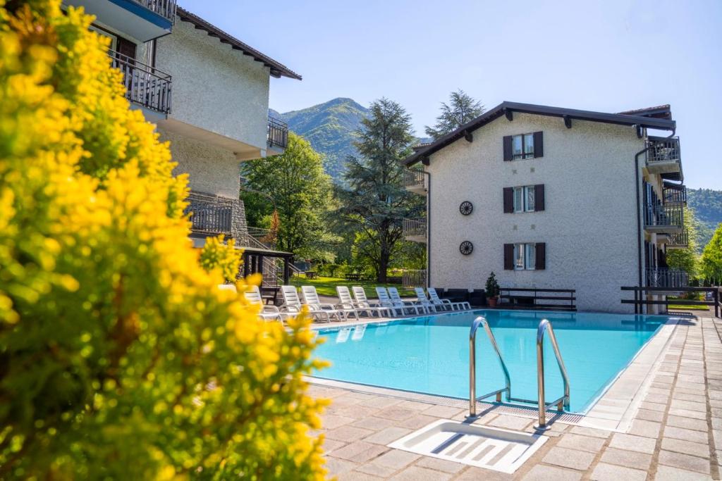 a hotel with a swimming pool in front of a building at Residence CATULLO in Bezzecca