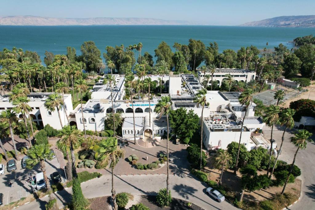 an aerial view of a large white building with palm trees at HI - Karei Deshe Hostel in Khirbet Minim