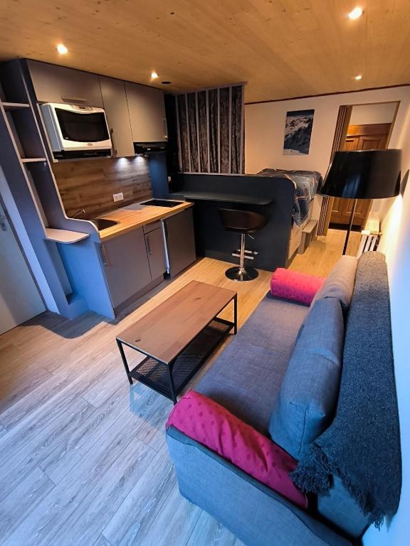 a living room with a couch and a piano at Cozy studio in a mountain village in Villar-dʼArène