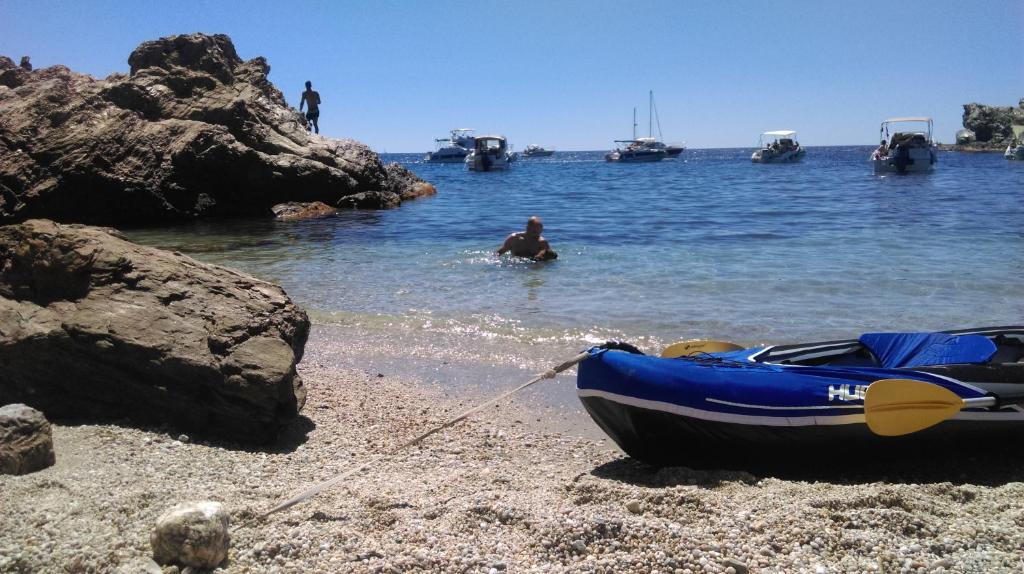 a man in the water next to a boat on the beach at La Petite Maison De Melanie 30m mer in Six-Fours-les-Plages