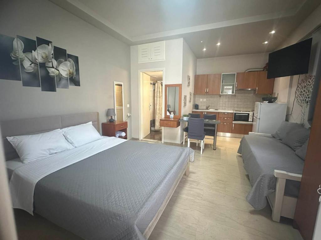 a bedroom with a bed and a couch and a kitchen at Angeligue Studio with Balcony in Ipsos