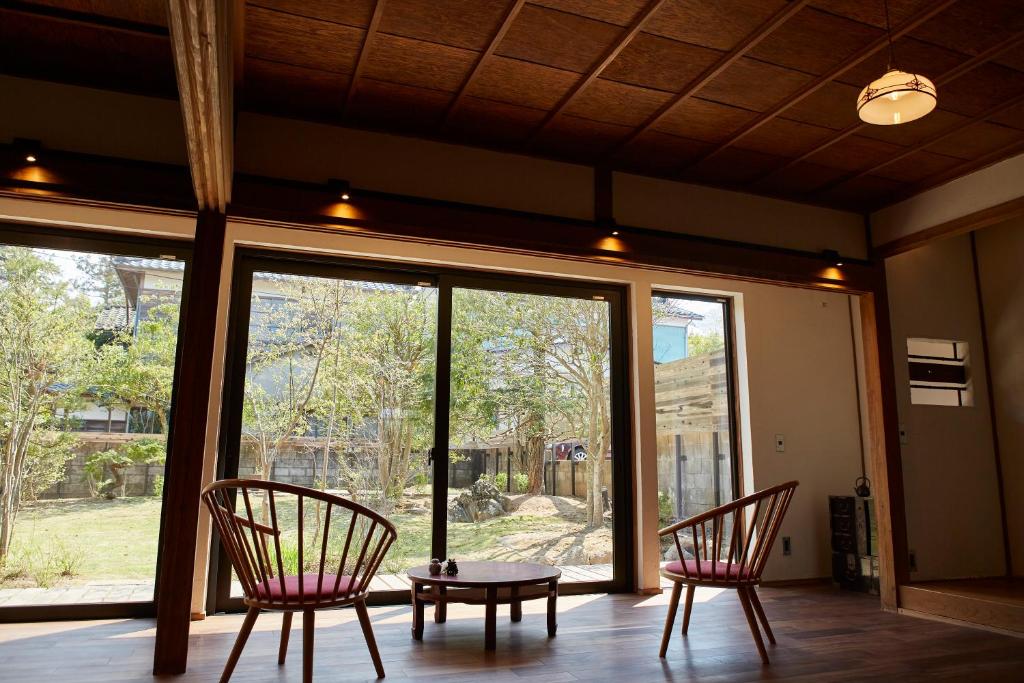 two chairs and a table in a room with windows at 岩室久元 in Niigata