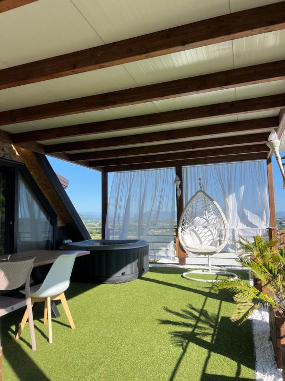 a living room with a table and chairs and grass at SunnyHill Villa in Shkodër