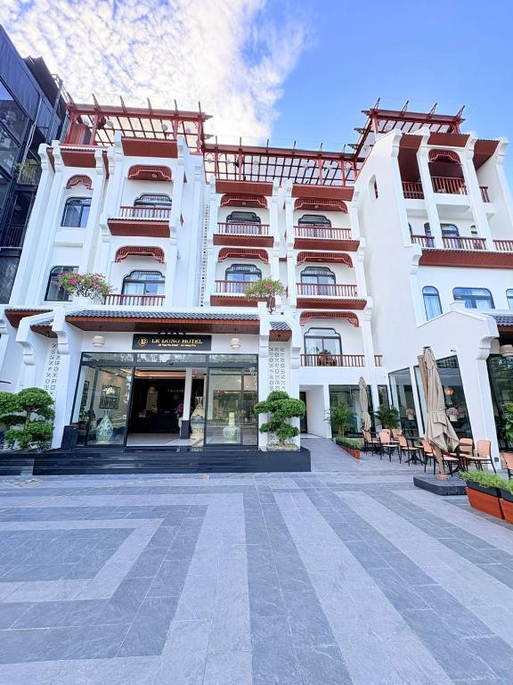 a large white building with a store in front of it at Le Dung Hotel in Tam Kỳ