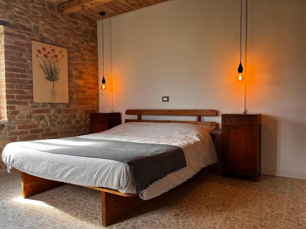 a bedroom with a bed and a brick wall at Agriturismo Angeli Sognanti in Cossignano
