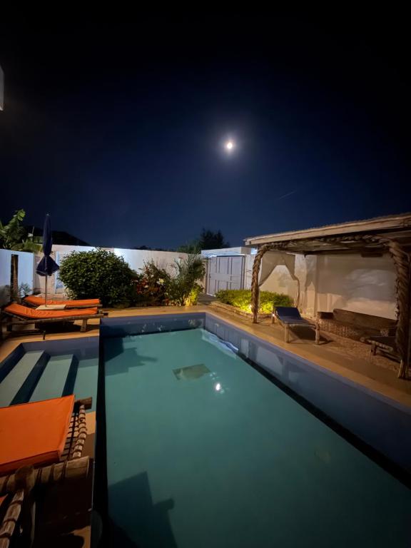 a swimming pool at night with the moon in the sky at La luna di zanzibar in Kiwengwa
