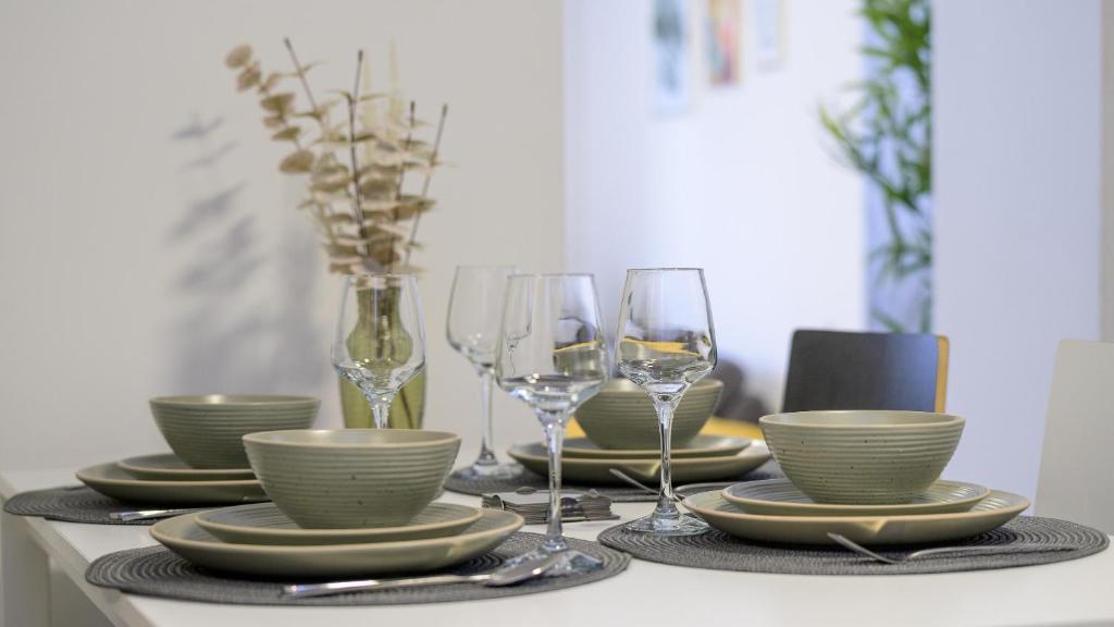 a table with plates and wine glasses on it at Apartman Grey in Jastrebarsko