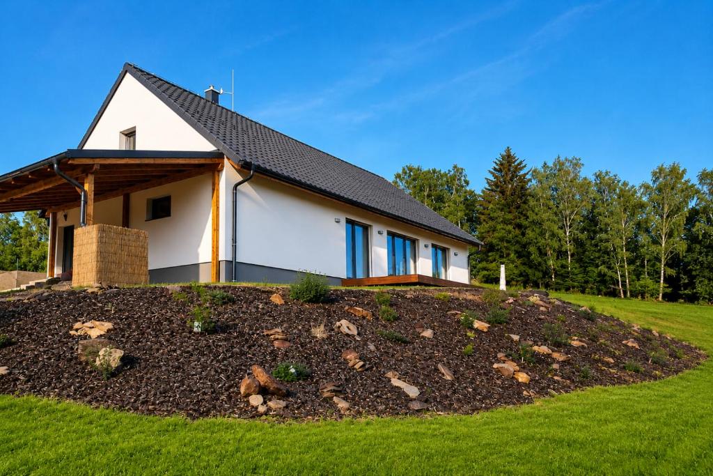 a house on top of a grassy hill at Na kopečku u lesa in Březová