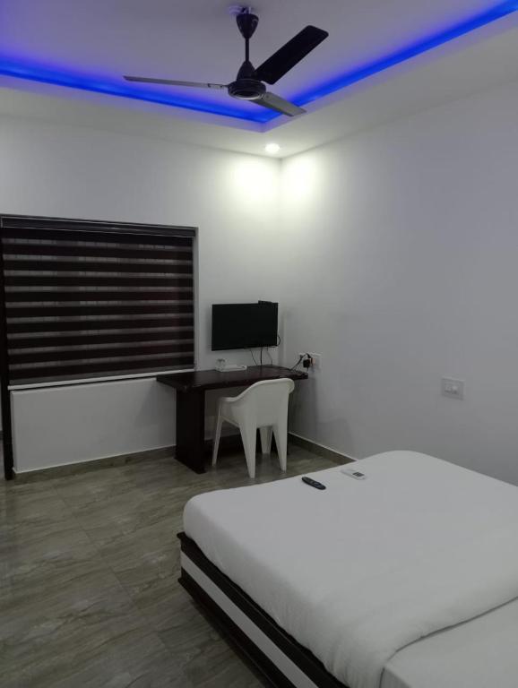 a bedroom with a bed and a desk with a computer at Zero One Residency in Quilāndi