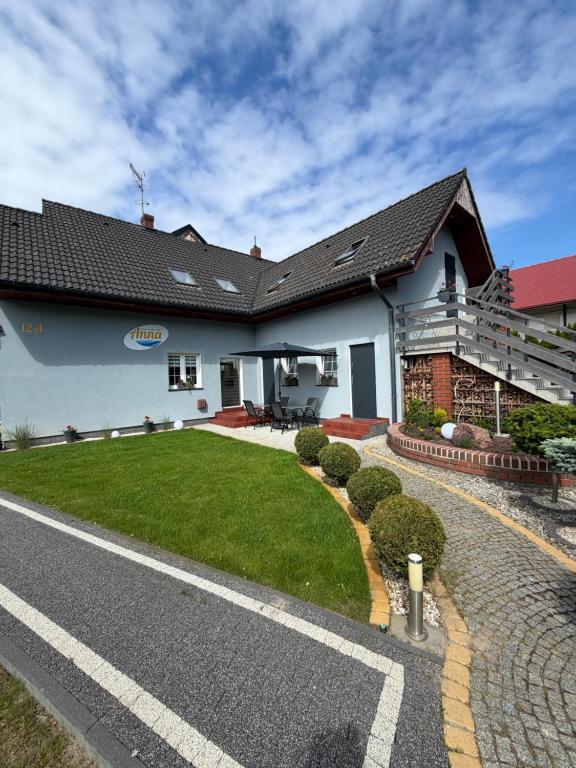 a house with a grass yard in front of it at DOM GOŚCINNY ANNA in Niechorze