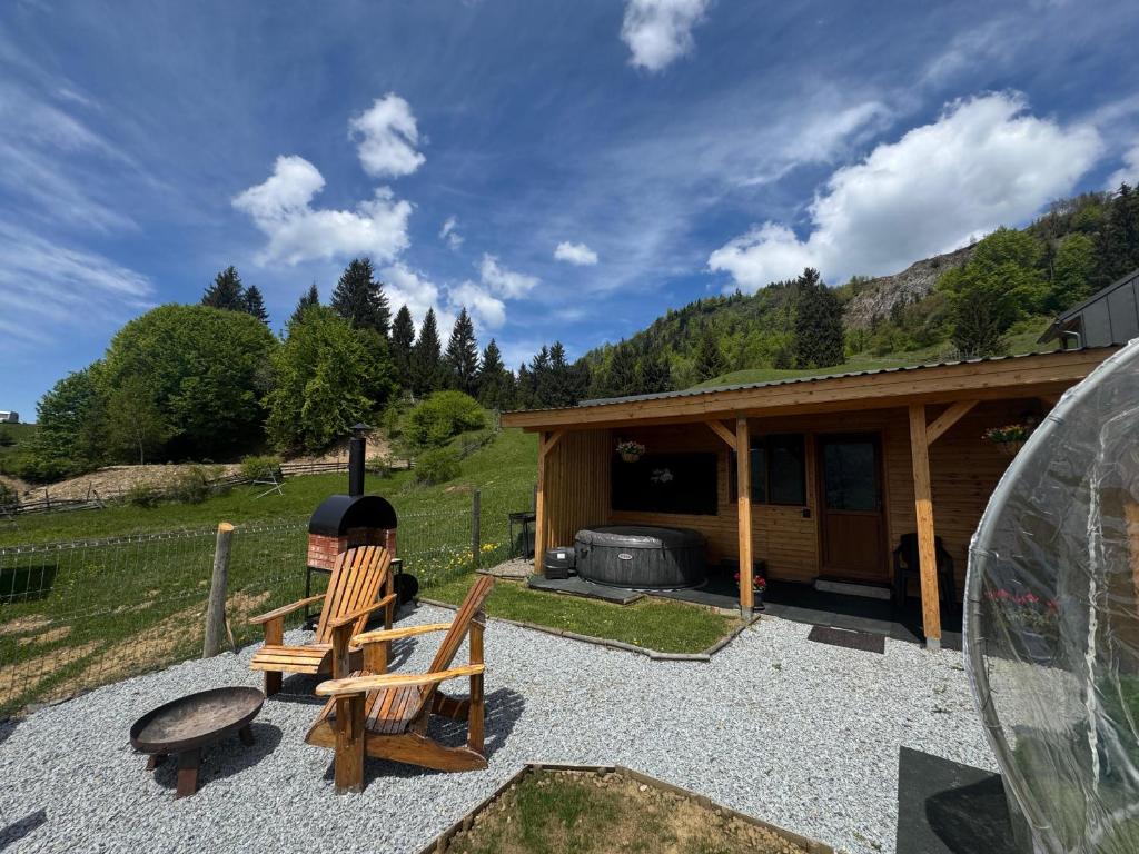 a cabin with two chairs and a grill in front of it at Tiny House Colibita in Colibiţa