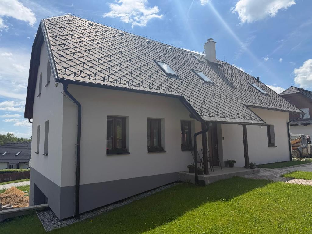 a white house with a gray roof at Apartmány Kadov 88 in Kadov