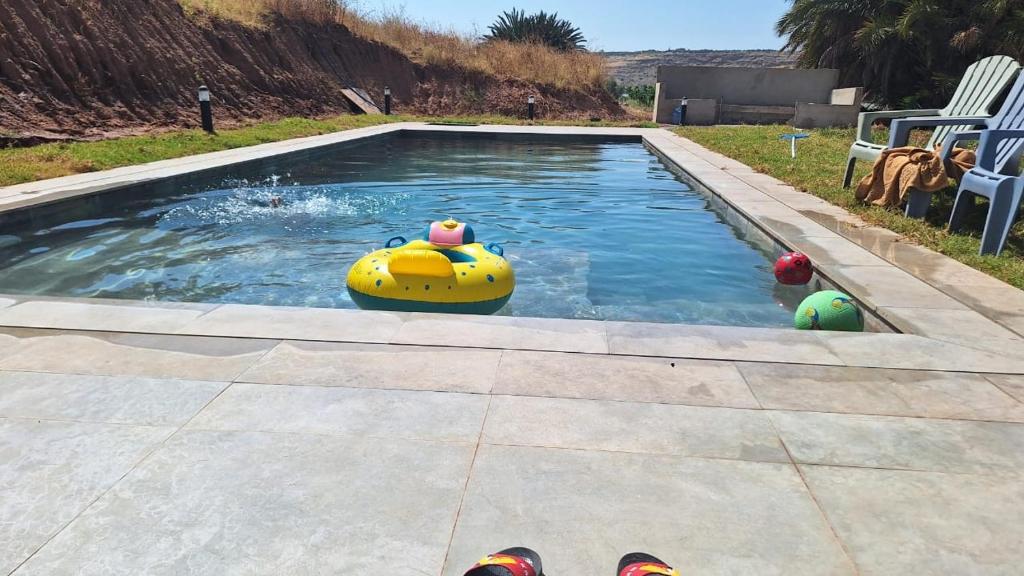a swimming pool with a toy in the water at Lake House Boulaouane in Douar Annbirat