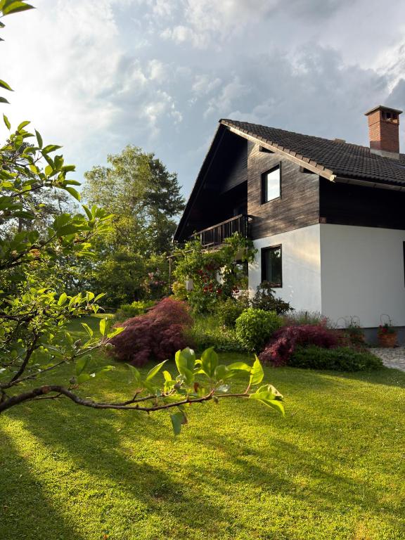 a house with a grassy yard next to a building at Apartment Ivana B in Lesce
