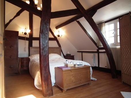 1 dormitorio con 1 cama grande y suelo de madera en L'Escapade de Marijac, en Lyons-la-Forêt